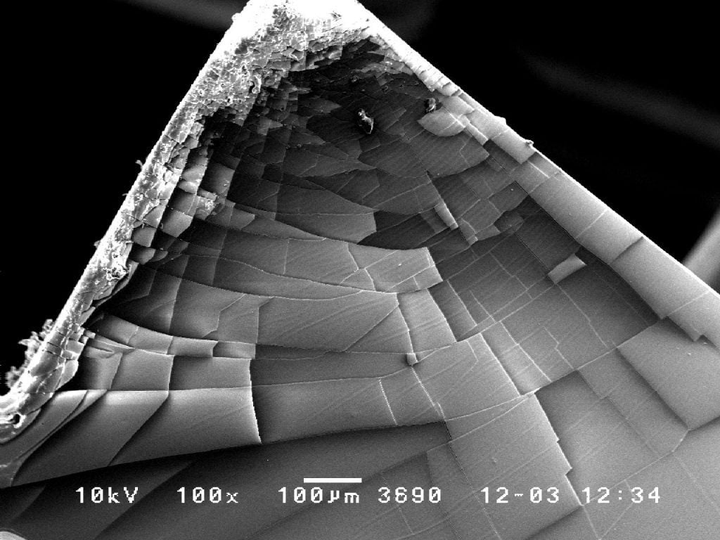 SEM - A pyramid of platinum found in a thick sputter deposited platinum coating at 100x.